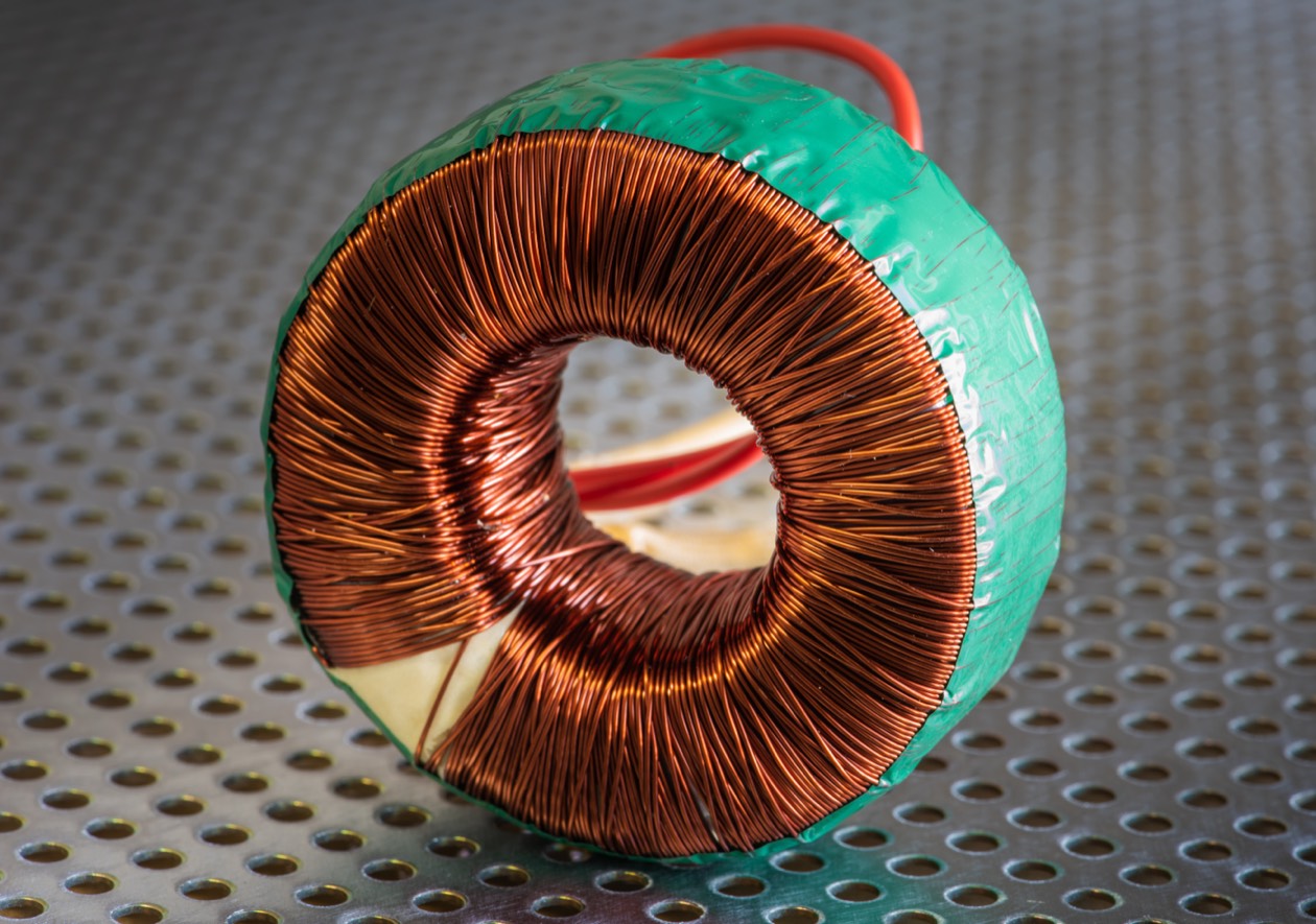 Toroidal core with green tape on perforated metal surface