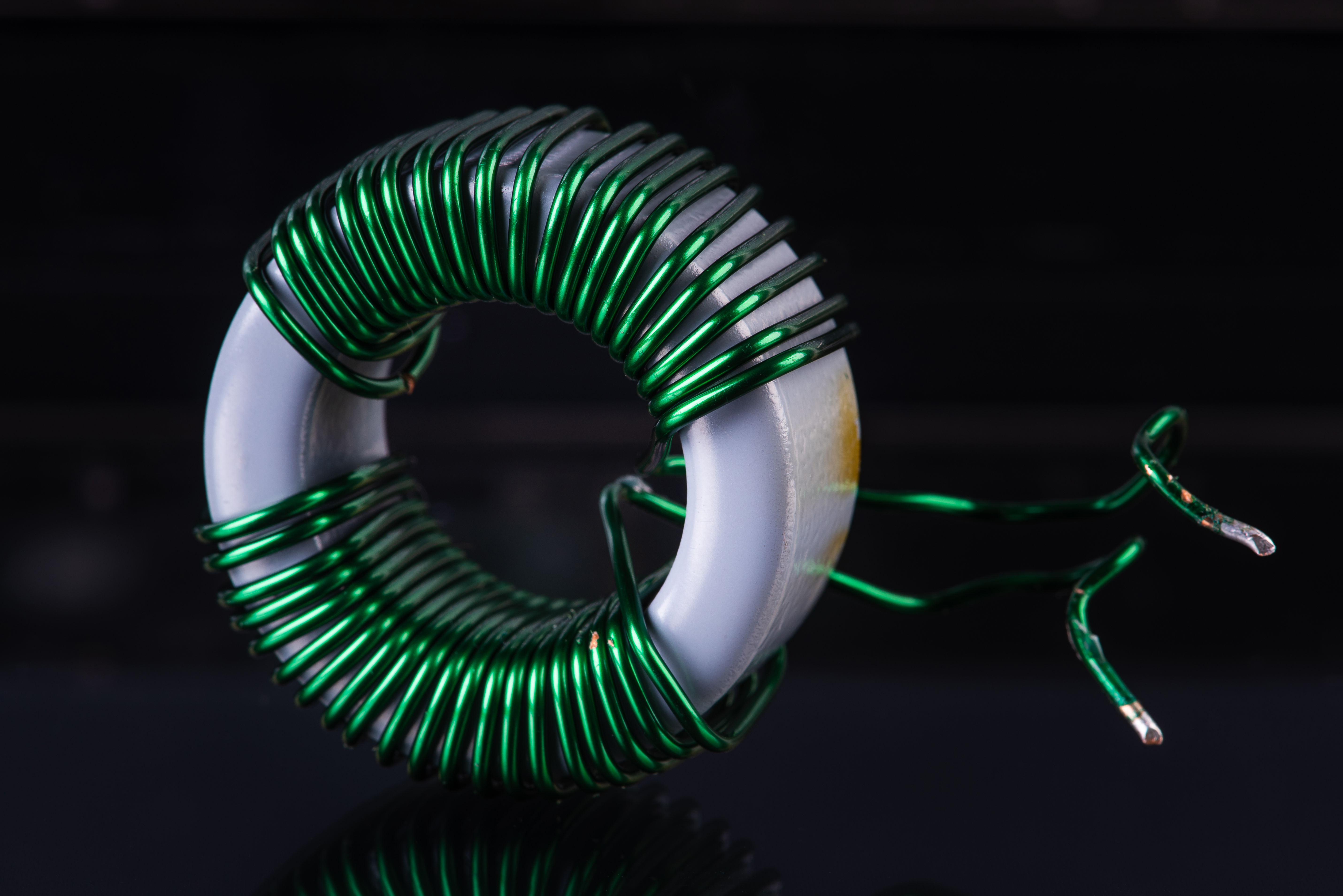 Toroidal inductor close-up with green enamel wire